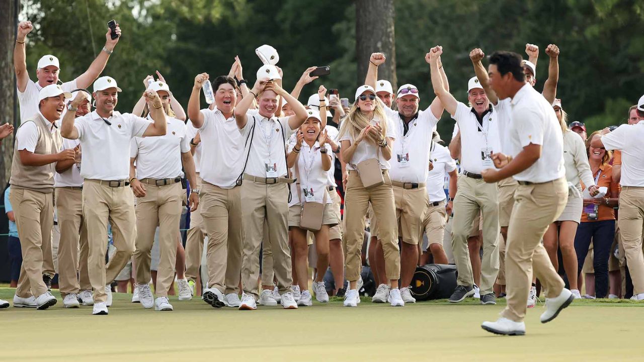 Korea's Tom Kim celebrates holing a putt at the Presidents Cup in front of his International teammates